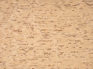Rustic burl wood veneer surface showcasing a symphony of tan and beige whirls