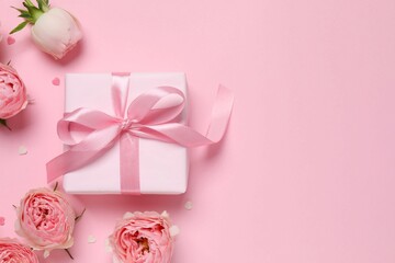 Beautiful pink peony roses with gift box on color background