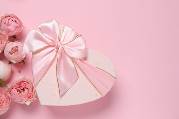 Beautiful pink peony roses with gift box on color background