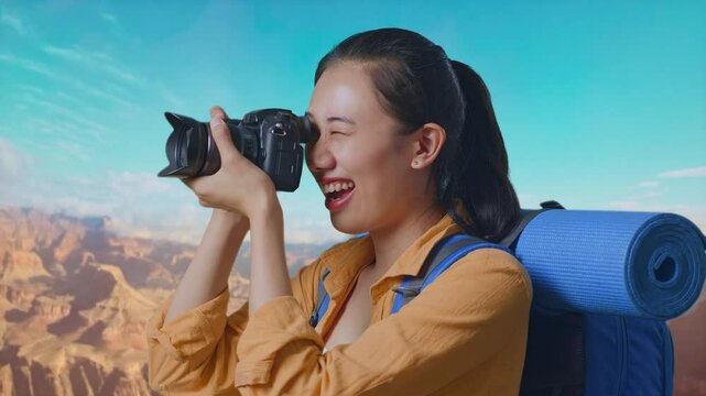 Close Up Side View Of Asian Female Hiker With Mountaineering Backpack Using A Camera Taking Picture While Traveling At The Top Of Mountain