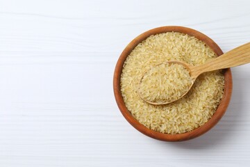 Raw brown rice in bowl on white background