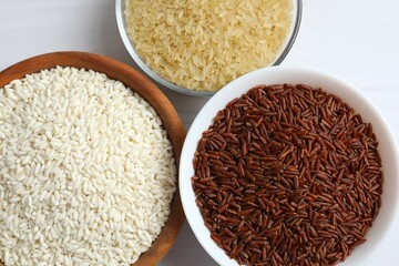 Different types of rice in bowls on table, closeup