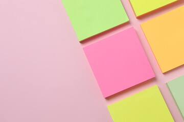 Multicolored paper stickers on a pink background