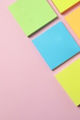 Multicolored paper stickers on a pink background