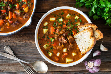 Beef vegetables goulash soup on wooden table