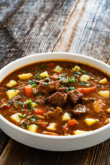 Beef vegetables goulash soup on wooden table