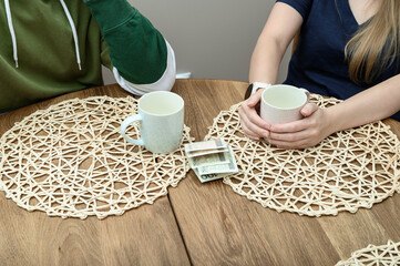 Kobieta i mężczyzna przy stoliku w restauracji piją herbatę, pieniądze za rachunek 