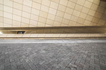 Low angle view of empty patterned stone pavement floor looking up at modern abstract geometric...