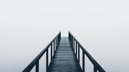 Obraz premium A dark wooden pier extends into a foggy body of water.
