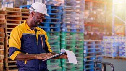 A warehouse worker doing inventory inspection on a clipboard in a storage warehouse.