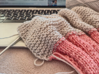 Currently working on a cozy and creative knitting project while using my laptop at home
