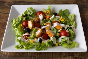 Crispy chicken Caesar salad with cherry tomatoes and creamy dressing for healthy lunch visuals