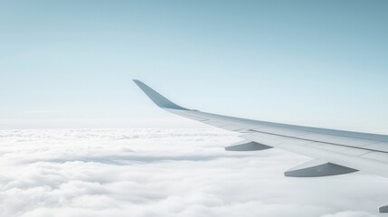 Obraz premium A view from an airplane window of the wing and clouds below.