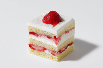 slice of strawberry shortcake with layers of sponge cake, whipped cream, and fresh strawberries on white background