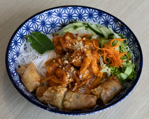 Asian chicken bowl with fresh vegetables and spring rolls for street food and lunch ideas