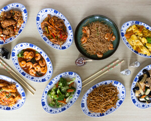 Top view of assorted Asian stir fry dishes and noodles with shrimp, vegetables and sauces for buffet or restaurant menu visuals