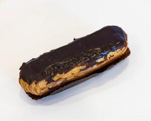 Classic chocolate éclair pastry on white background for dessert and bakery visuals