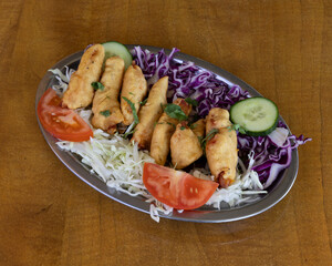 Crispy fried rolls served with shredded cabbage salad, tomato and cucumber for vegetarian appetizer visuals
