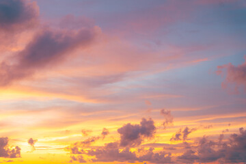 Colorful twilight scene with orange pink clouds glowing warmly against a cool, fading sky.