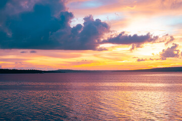 Serene beach scene with sunset sky painted in orange, pink, and subtle twilight blue tones.