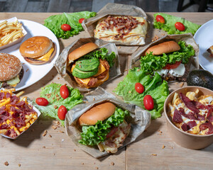 An assortment of burgers and fries displayed on a wooden surface top