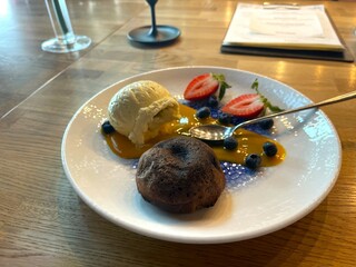 Chocolate fondant on a plate with berries, ice cream and mousse