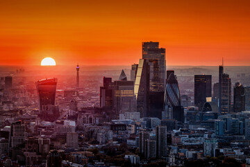 Elevated view of a fiery sunset behind the urban skyline of the City of London, England