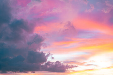Evening sky glows with fiery orange and soft pink clouds, melting into deep blue twilight