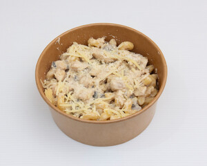 Pasta with creamy sauce and cheese in a brown bowl on white surface