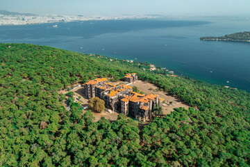 Buyukada Greek Orphanage. Aerial view of the Buyukada Greek Orphanage on a coastal hill surrounded by lush vegetation with the sea in the background. Istanbul, Turkey.