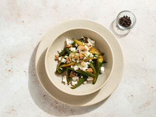 Asian Quick Pickled Cucumbers in Salad. Delicious salad with Asian style pickles cucumbers, goat cheese and walnuts nuts. Ideas and recipes for healthy breakfast, lunch or dinner. Top view or flat lay