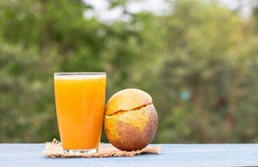 Indian Bael Fruit Juice or Sharbat in a Glass or Wood Apple Isolated on Wooden Background with Copy Space, Also Known as Aegle Marmelos, Bengal Quince, Japanese Bitter Orange or Stone Apple