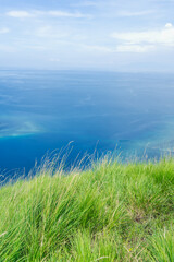 Green hills roll into the blue sea in this tranquil coastal view. Perfect summer background for vacations.