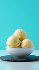 Creamy vanilla ice cream scoops in a white bowl.