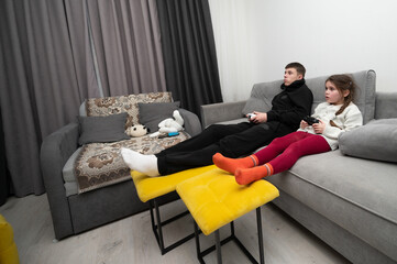 Gaming siblings enjoy an exciting evening in a cozy living room filled with fun, laughter, and...