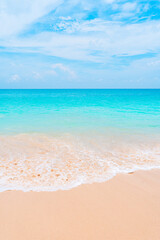 Turquoise ocean waves and white sand beach on a sunny day. Summer vacation background concept.
