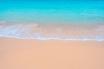 Turquoise waters lap a white sandy beach under a brilliant sun summer at its finest.