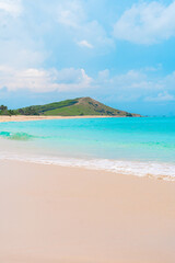 Relaxing beach scene with turquoise surf and white sand beneath a bright summer sun.