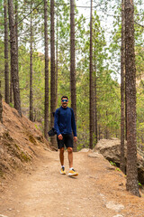 Obraz premium Tourist hiking in the forest path to roque nublo, gran canaria
