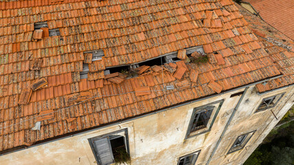 Aerial view of a broken roof with red tiles.