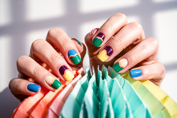 Fototapeta premium Womans Hands With Stylish Nail Art Holding A Colorful Paper Fan Decoration