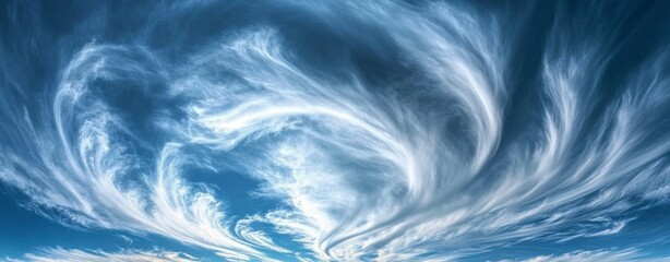 Obraz premium Swirling White Clouds Against Blue Sky Creates a Dramatic Weather Pattern