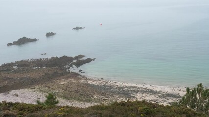 An aerial view of the coastline on a foggy day. Erquy, France - March 26, 2025. 
