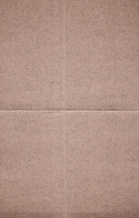 Fototapeta premium Close-up scan of high-quality, recycled brown paper with fine fiber details and subtle horizontal and vertical fold marks. This detailed texture is ideal for designers seeking authentic paper backs.