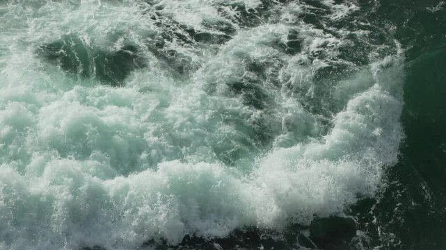 Ocean waves water crashing violently at shore during daytime creating whitewater