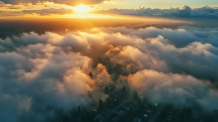 Obraz premium Golden Sunset Cloudscape: Aerial View of a Town Submerged in Mist