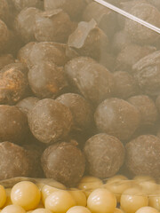 Chocolate coated snacks arranged in a display case at a market