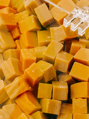 Colorful assortment of caramel candy squares displayed in a clear container