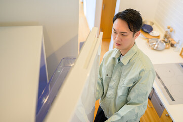 冷蔵庫を点検する日本人男性