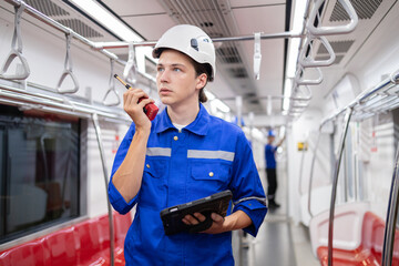 Portrait of young engineer of electric locomotive holding tablet in train